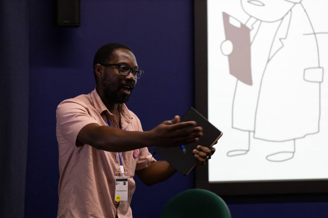 Emmanuel presenting at a workshop, gesturing towards the audience